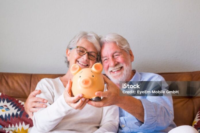 Smiling Senior Couple Holding Piggy Bank