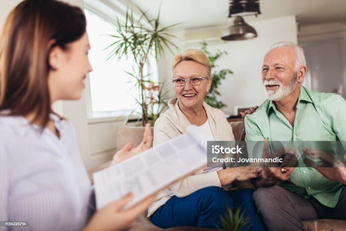 Positive aged couple consulting with insurance agent
