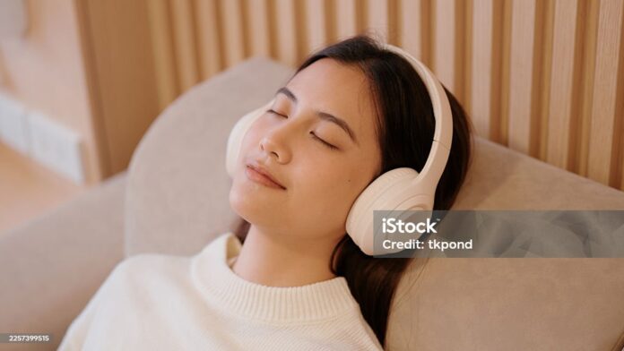 Taking a relaxing nap on a comfy sofa with wireless headphones.